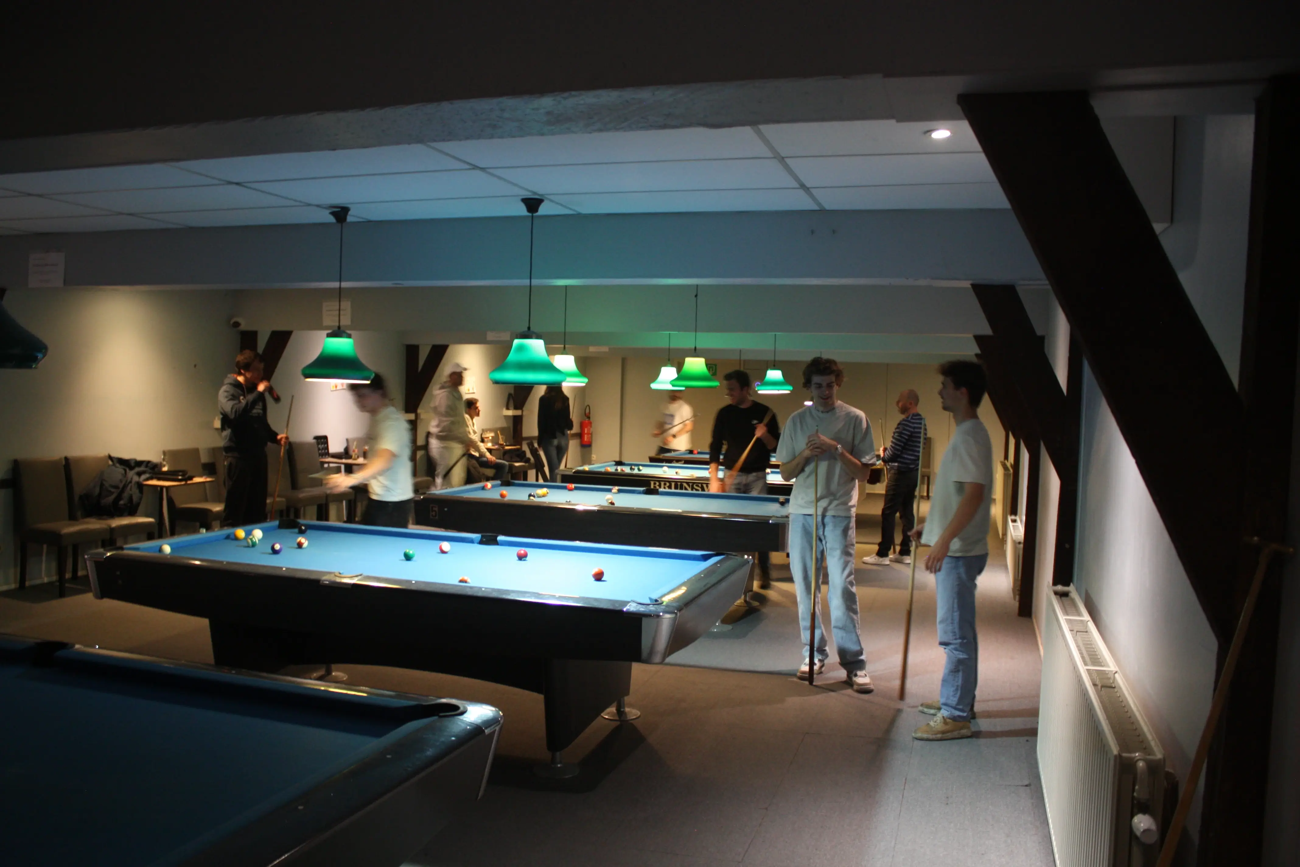 Lege pool tafel waar in de achtergrond mensen aan het poolen zijn.